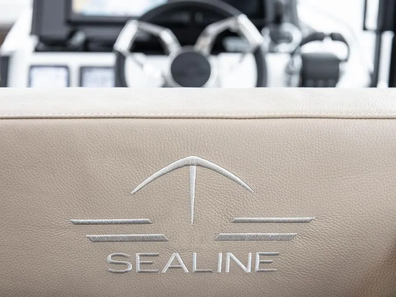 Slide: The Image of 2025 Sealine C390 yacht interior with embroidered logo on beige upholstery. - 10