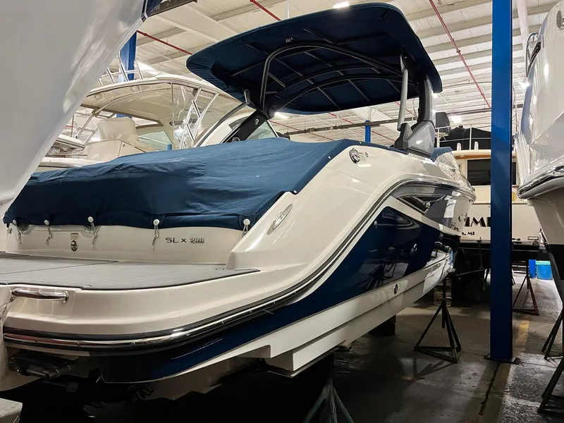 Slide: The Image of 2017 Sea Ray 280 SLX boat in storage, covered and elevated on stands. - 2