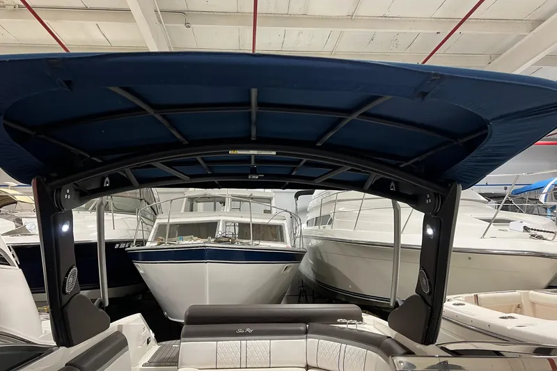 Slide: The Image of 2017 Sea Ray 280 SLX boat with blue canopy in a marina setting. - 20