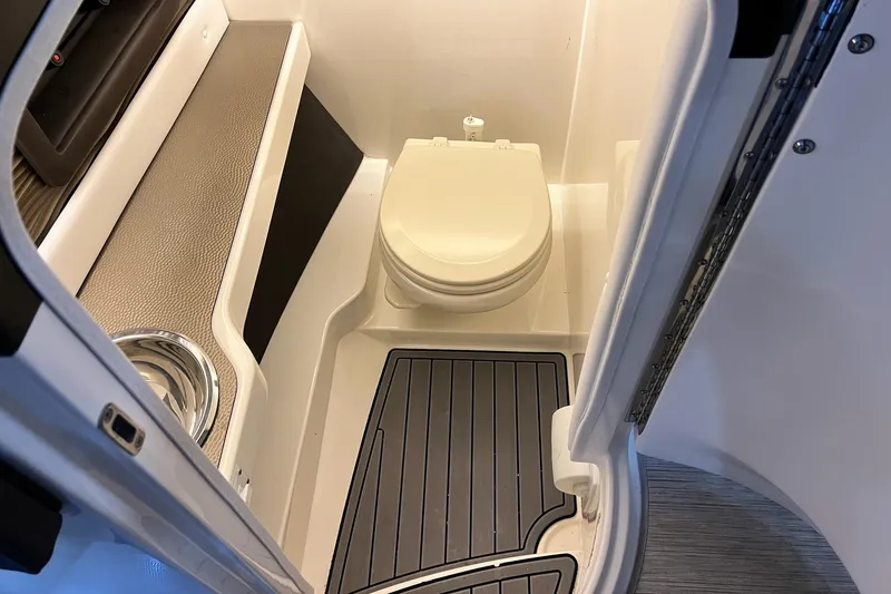 Slide: The Image of 2017 Sea Ray 280 SLX boat interior with compact marine toilet and flooring. - 25