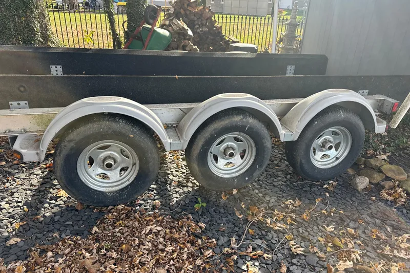 Slide: The Image of Triple-axle trailer parked on gravel, surrounded by autumn leaves. - 31