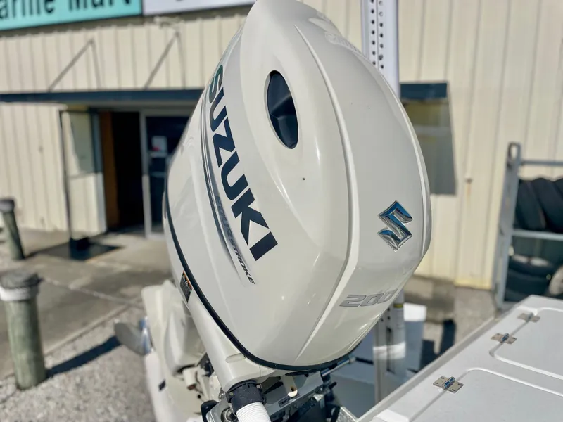 Slide: The Image of Suzuki outboard motor on a 2020 Long Bay 230 Bay boat, parked outside a building. - 34