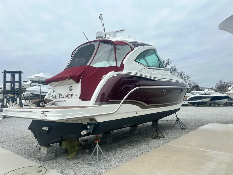 Slide: The Image of 2012 Formula 45 Yacht with maroon canopy, docked on gravel. - 4