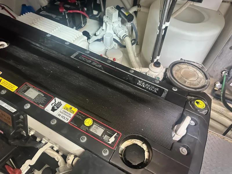 Slide: The Image of Engine compartment of a 2012 Formula 45 Yacht, showcasing mechanical components and warning labels. - 58