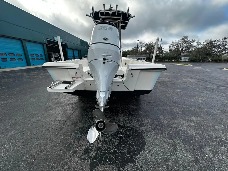 Slide: The Image of 2022 Bulls Bay 2400 boat with outboard motor, parked on asphalt near a blue building. - 5