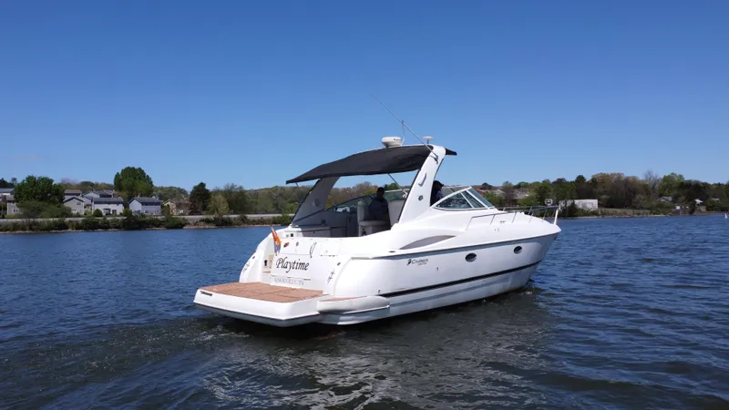 Slide: The Image of 2004 Cruisers Yachts 370 Express on a serene lake under clear blue skies. - 12