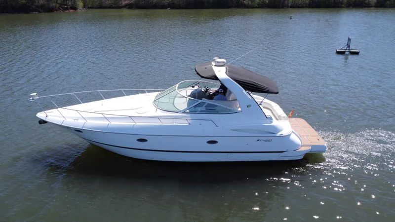 Slide: The Image of 2004 Cruisers Yachts 370 Express on calm water, side view with black canopy. - 14