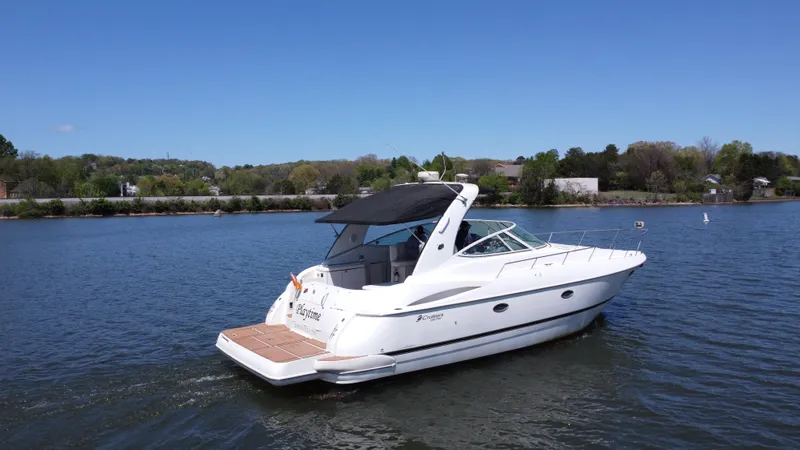 Slide: The Image of 2004 Cruisers Yachts 370 Express on a serene lake under a clear blue sky. - 10