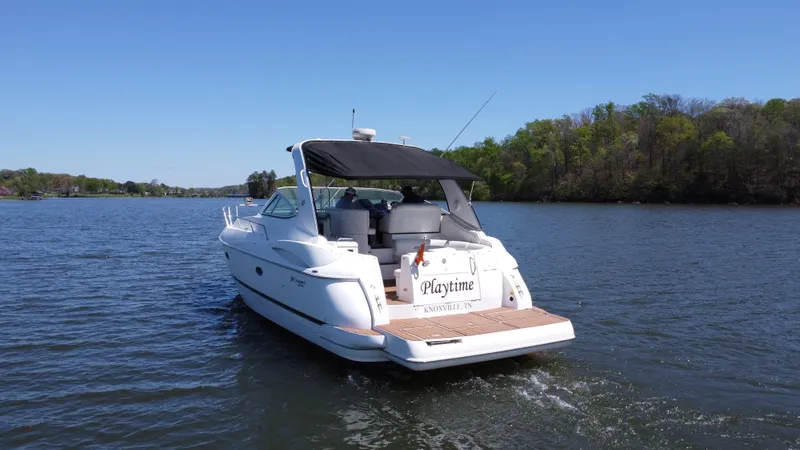 Slide: The Image of 2004 Cruisers Yachts 370 Express on a serene lake, surrounded by lush greenery. - 11