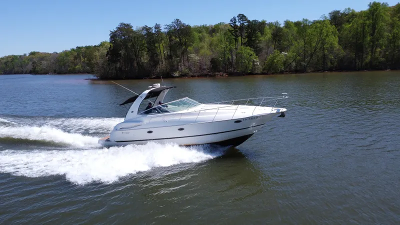 Slide: The Image of 2004 Cruisers Yachts 370 Express speeding on a scenic lake. - 5