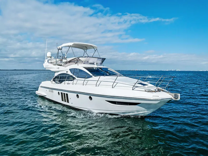 Slide: The Image of 2014 Azimut 45 Fly yacht cruising on open water under a clear blue sky. - 1