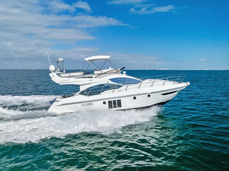 Slide: The Image of 2014 Azimut 45 Fly yacht cruising on open water under clear blue skies. - 10