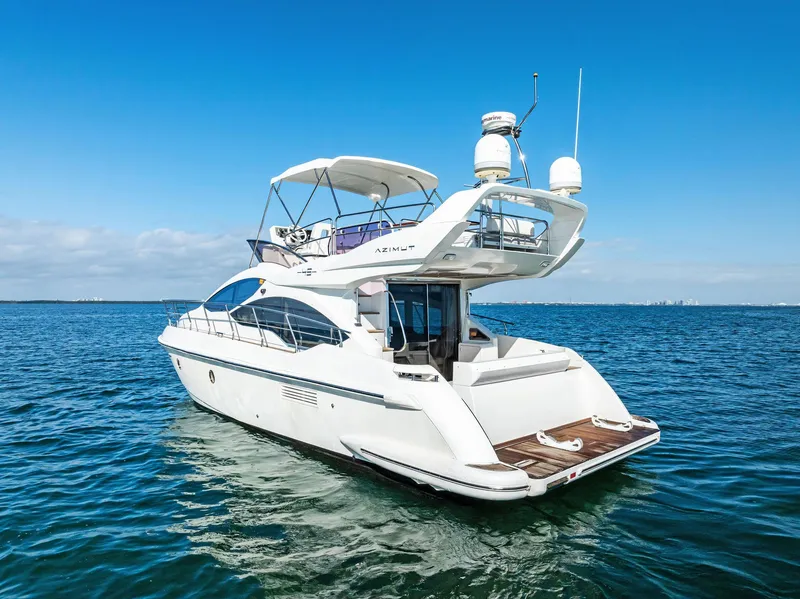Slide: The Image of 2014 Azimut 45 Fly yacht cruising on open water under clear blue skies. - 13