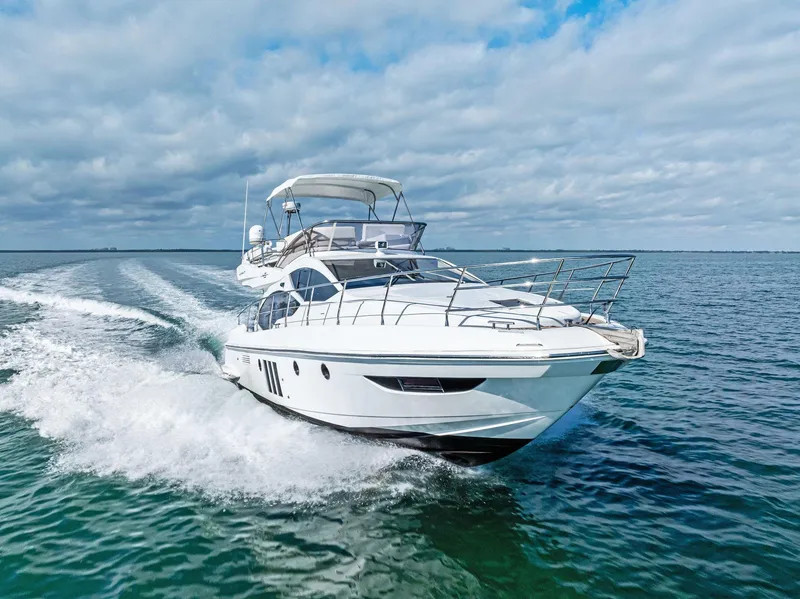 Slide: The Image of 2014 Azimut 45 Fly yacht cruising on open water under cloudy skies. - 9