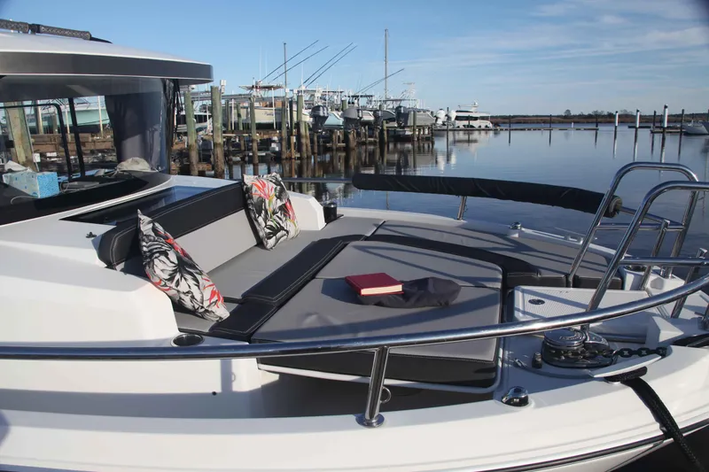 Slide: The Image of 2020 Jeanneau NC Sport 895 boat with cushioned seating and scenic marina view. - 10