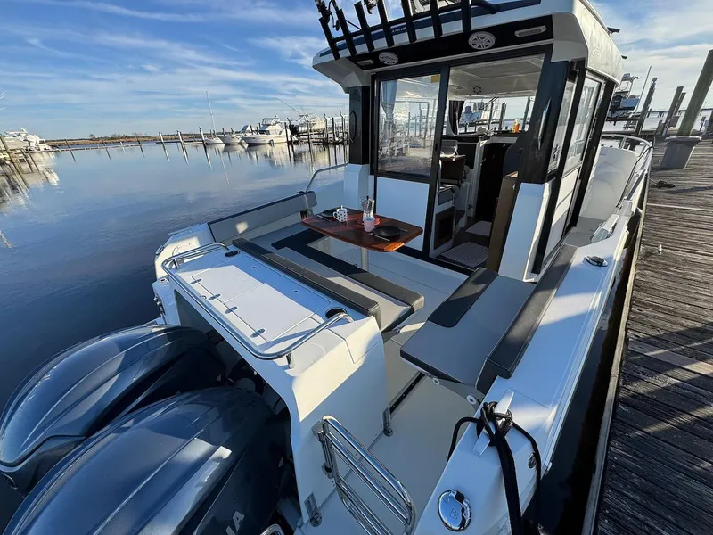 Slide: The Image of 2020 Jeanneau NC Sport 895 boat docked, featuring spacious deck and twin engines. - 6