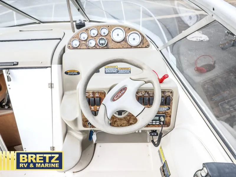 Slide: The Image of Bayliner 2455 2000 boat dashboard with steering wheel and gauges. - 13