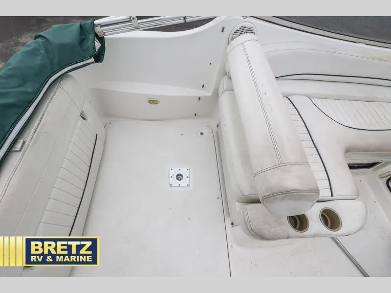Slide: The Image of 2000 Bayliner 2455 boat interior with white seating and cup holders. - 15