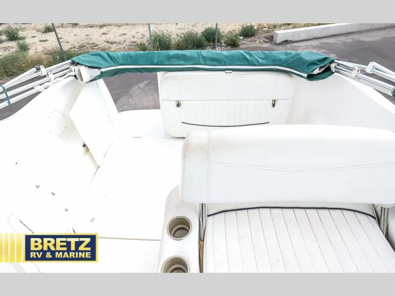 Slide: The Image of 2000 Bayliner 2455 boat interior with white seating and green cover. - 16