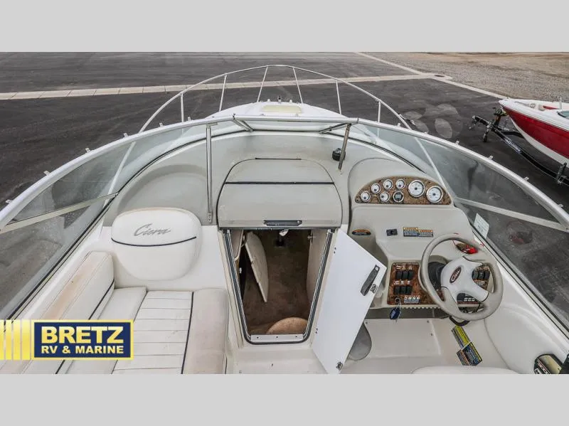 Slide: The Image of 2000 Bayliner 2455 boat interior with helm, seating, and cabin entrance. - 19