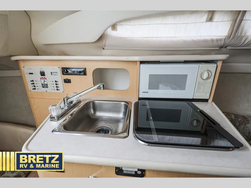 Slide: The Image of Bayliner 2455 2000 model boat kitchen with sink, stove, and microwave. - 25