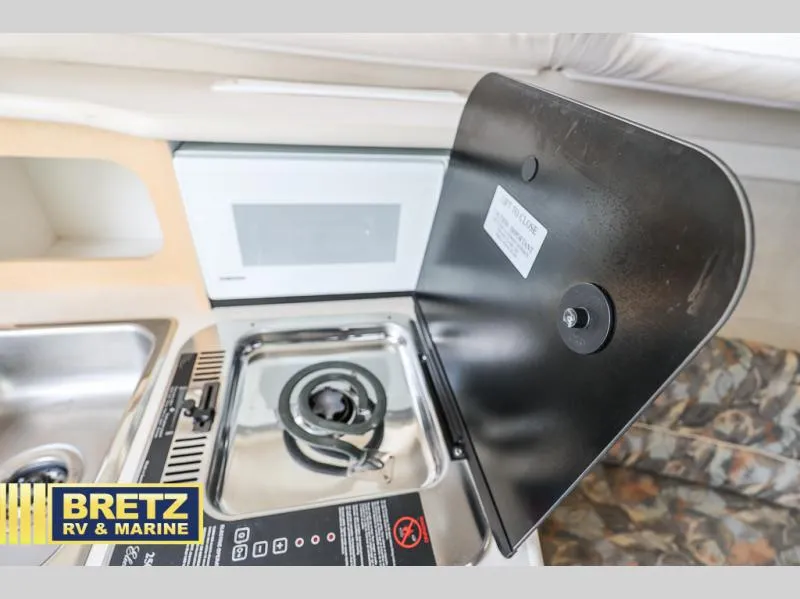 Slide: The Image of 2000 Bayliner 2455 boat interior with stove and sink in kitchenette. - 26