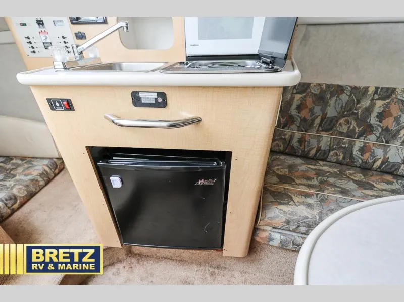 Slide: The Image of Bayliner 2455 2000 model interior with kitchenette, mini fridge, and seating area. - 27