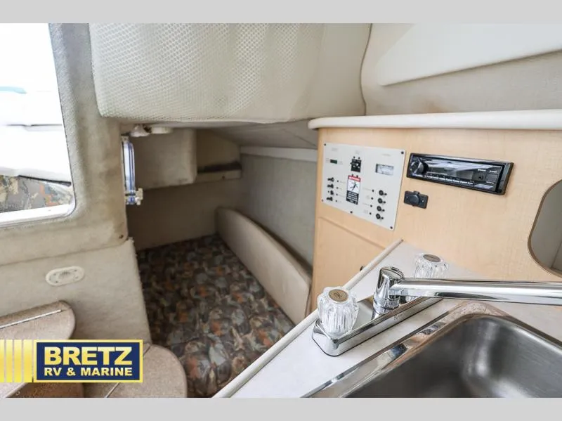 Slide: The Image of Interior of 2000 Bayliner 2455 boat with sink, control panel, and seating area. - 29