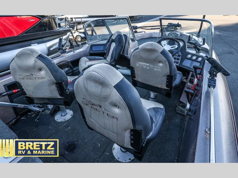 Slide: The Image of 2015 Skeeter WX1850 boat interior with seating and dashboard, displayed at Bretz RV & Marine. - 16