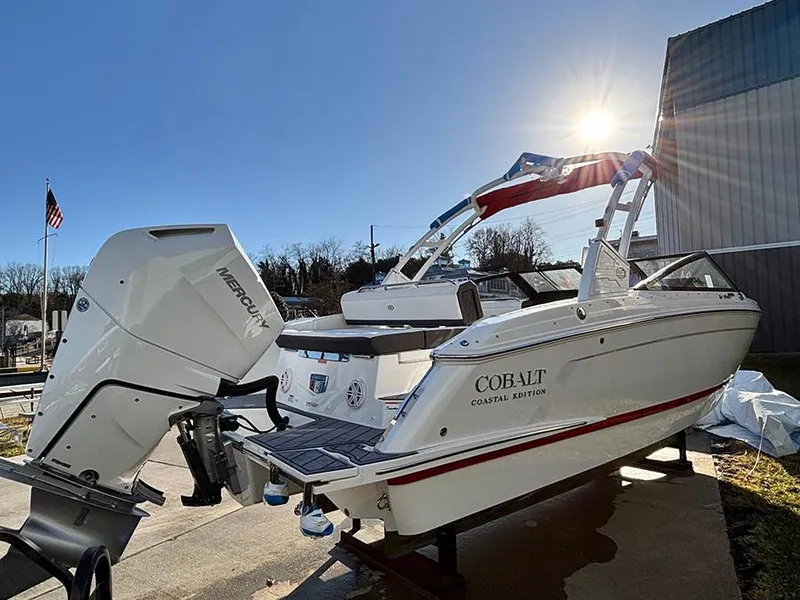 Slide: The Image of 2025 Cobalt R4 Outboard boat, coastal edition, with Mercury engine, under bright sun. - 2