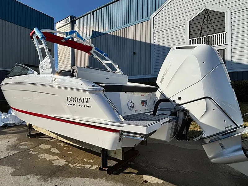 Slide: The Image of 2025 Cobalt R4 Outboard boat with white exterior, parked outdoors near a building. - 4