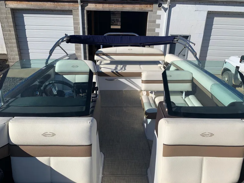 Slide: The Image of 2017 Marker One ML4 boat interior with beige seating and glass windshields. - 13