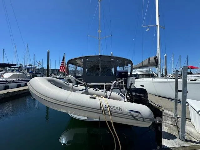 Slide: The Image of 2007 Beneteau 49 yacht docked with inflatable dinghy, marina background. - 17