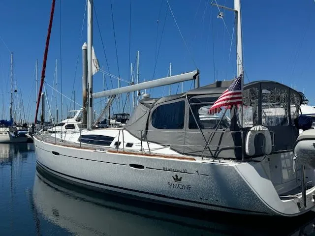 Slide: The Image of 2007 Beneteau 49 sailboat docked in marina, featuring sleek design and American flag. - 18