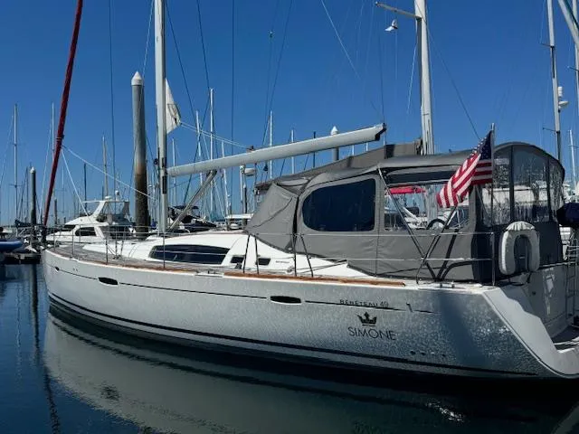 Slide: The Image of 2007 Beneteau 49 sailboat docked in marina, featuring sleek design and American flag. - 19