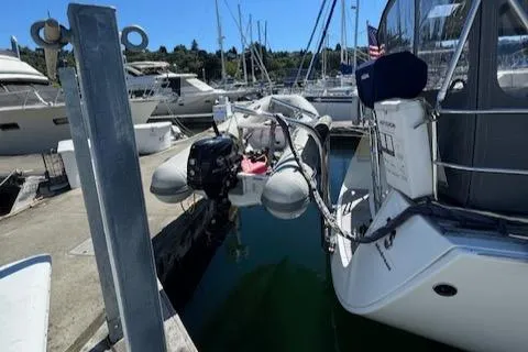 Slide: The Image of Beneteau 49 yacht docked with inflatable dinghy, 2007 model, in a marina setting. - 28