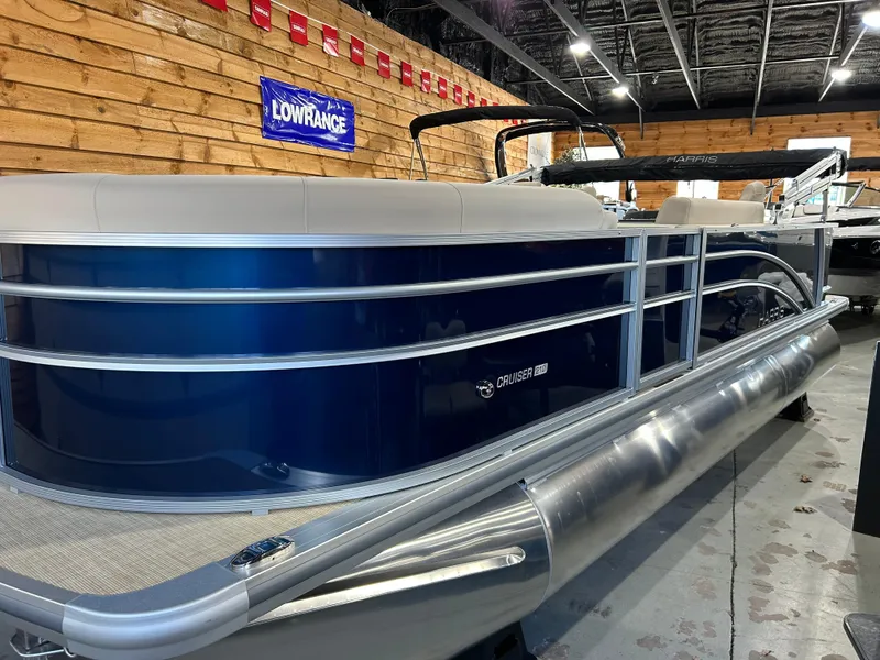 Slide: The Image of 2025 Harris Cruiser 210 FC pontoon boat in showroom, featuring sleek design and modern amenities. - 2