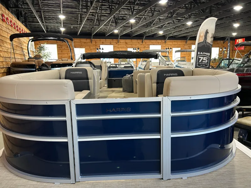 Slide: The Image of 2025 Harris Cruiser 210 FC pontoon boat in showroom, featuring sleek design and comfortable seating. - 7