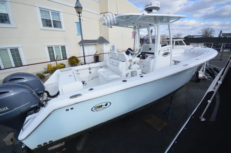The Image of 2015 Sea Hunt Gamefish 27 boat with dual Yamaha engines, docked outdoors. - 0