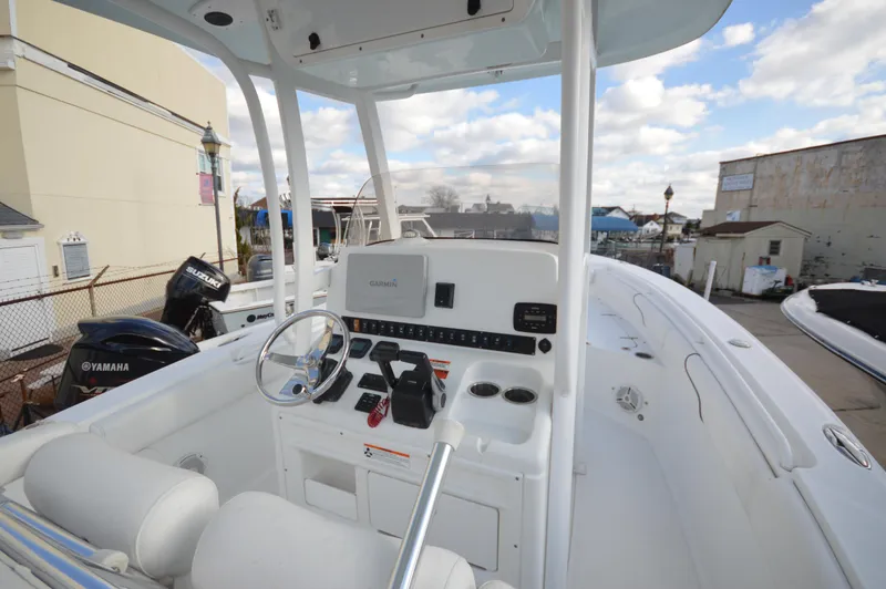Slide: The Image of 2015 Sea Hunt Gamefish 27 boat cockpit with steering wheel and controls. - 11