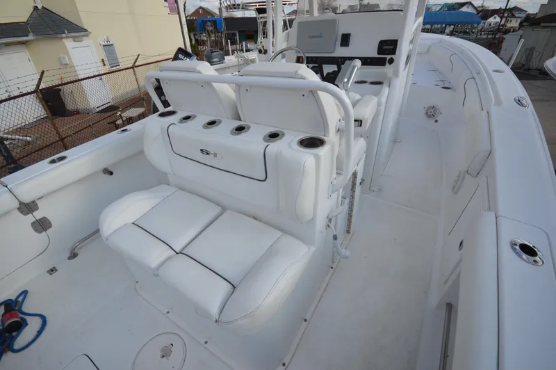 Slide: The Image of 2015 Sea Hunt Gamefish 27 boat interior with white seating and fishing rod holders. - 16