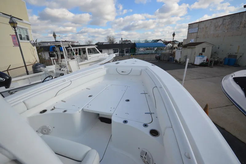Slide: The Image of 2015 Sea Hunt Gamefish 27 boat docked under cloudy sky. - 19