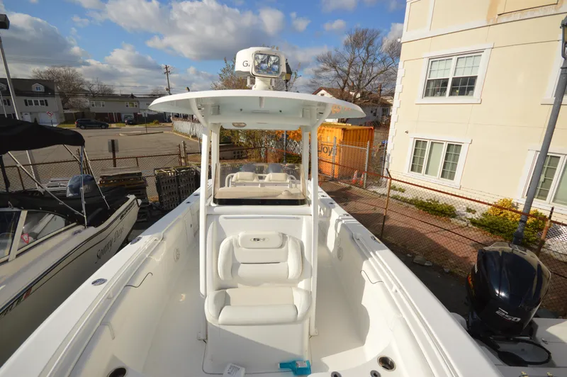 Slide: The Image of 2015 Sea Hunt Gamefish 27 boat with center console and seating, docked near buildings. - 21