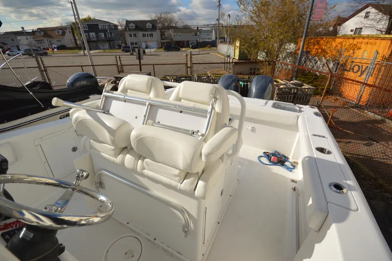 Slide: The Image of 2015 Sea Hunt Gamefish 27 boat interior with white seating and steering wheel. - 22