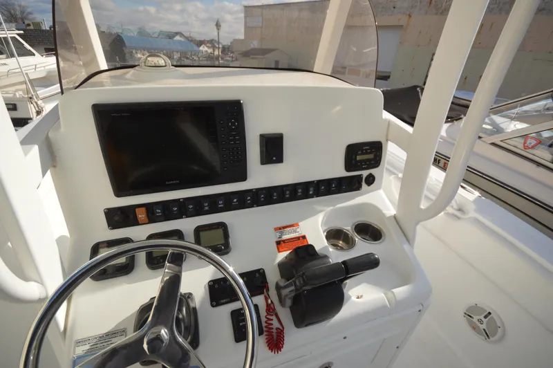 Slide: The Image of 2015 Sea Hunt Gamefish 27 helm with steering wheel and navigation controls. - 23
