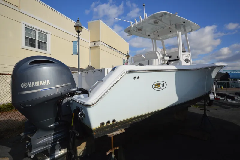 Slide: The Image of 2015 Sea Hunt Gamefish 27 boat with Yamaha engine, docked outdoors. - 5