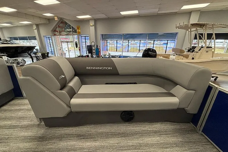 Slide: The Image of 2025 Bennington S 21 Cruise boat seating in showroom, featuring sleek gray upholstery. - 15