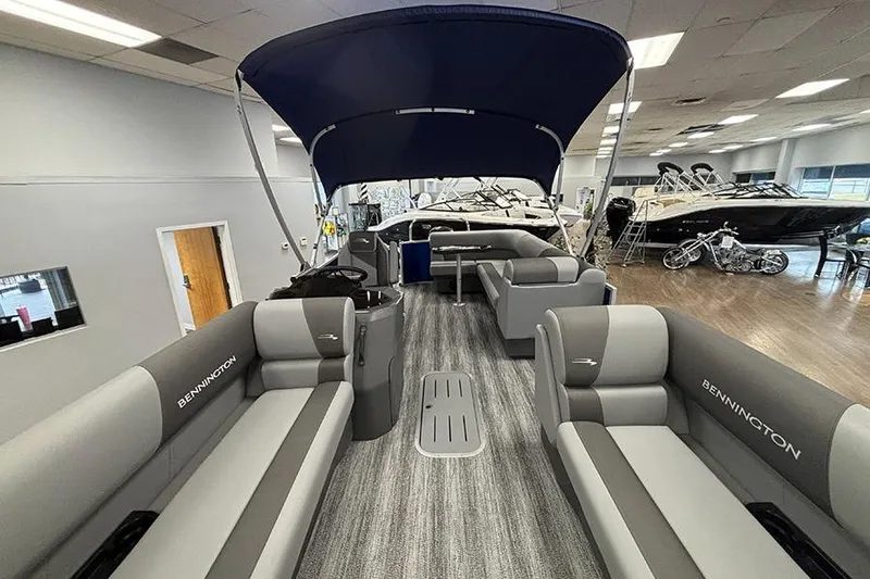 Slide: The Image of 2025 Bennington S 21 Cruise pontoon boat interior with gray seating and blue canopy. - 16