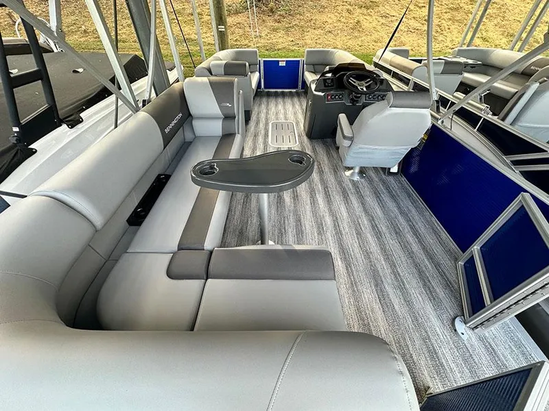 Slide: The Image of 2025 Bennington S 21 Cruise pontoon boat interior with gray seating and modern helm. - 2