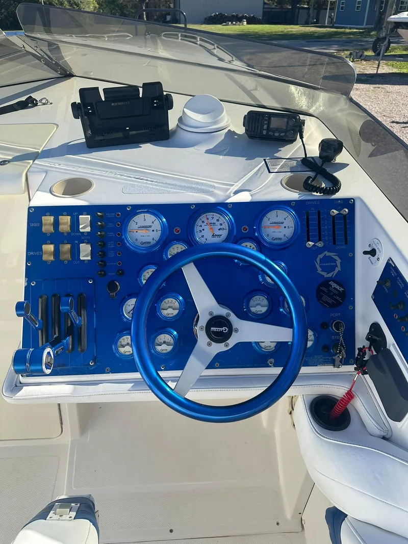 Slide: The Image of 2003 Fountain 35 Executioner boat dashboard with blue steering wheel and gauges. - 10